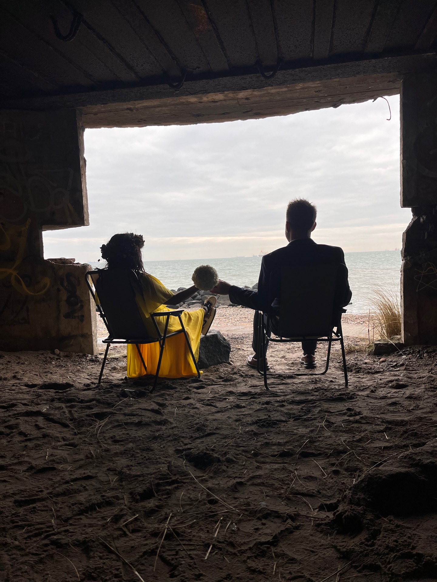 To personer i en gammel bunker med udsigt over havet